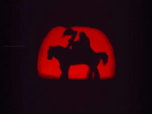 Pumpkin carving of Frank Frazetta's Death Dealer, a dark warrior with axe aloft atop an intimidating steed.
