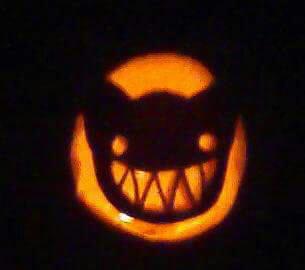 Pumpkin carving of the cat from Azumanga Daioh, a menacing grin of sharp teeth.