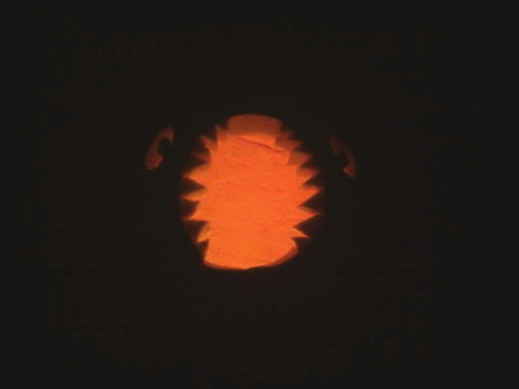 Pumpkin carving of a face with a gaping toothy maw.