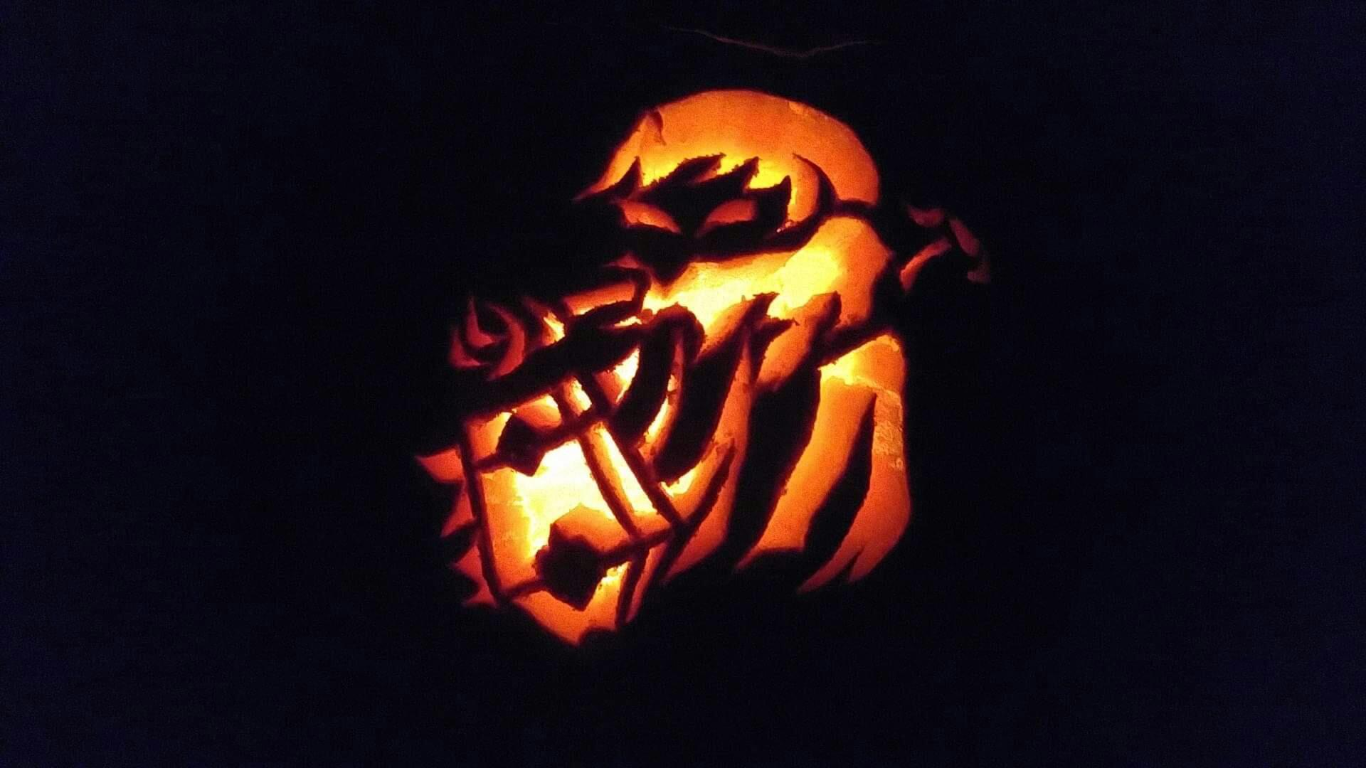 Pumpkin carving of a Poe from The Legend of Zelda, a menacing ghost in a tattered cloak holding out a lantern.