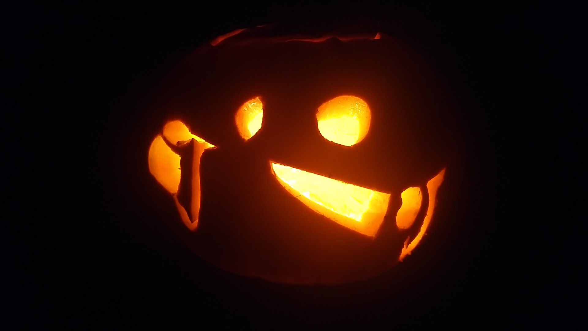 Pumpkin carving of a Tonberry from Final Fantasy, a small creature in a robe carrying a lantern and a large knife.
