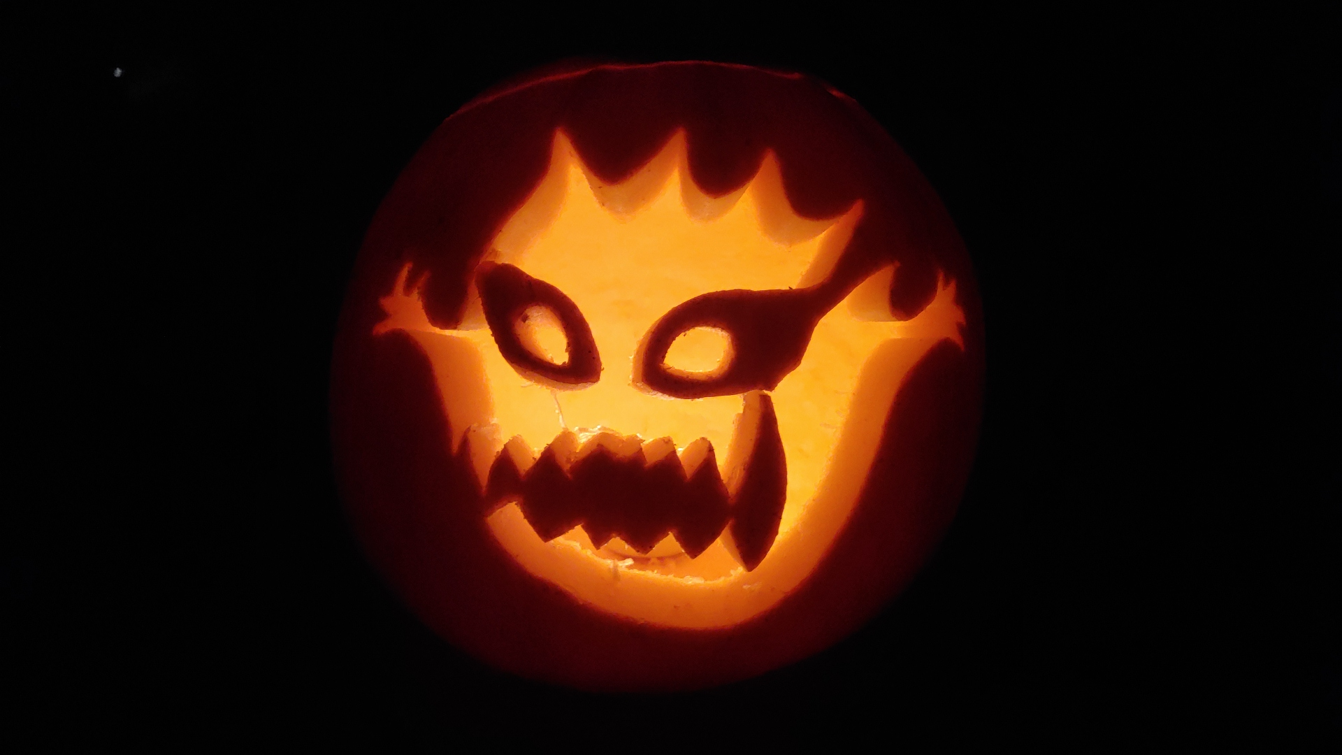 Pumpkin carving of a Bomb from Final Fantasy, a round firey creature with a menacing face.